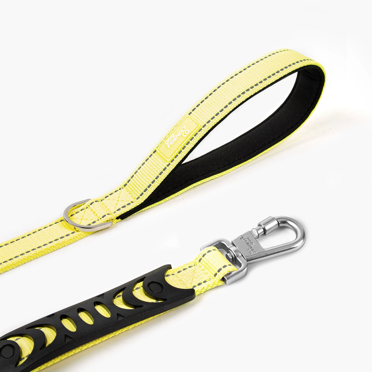 Close-up of the yellow bungee dog leash showing the padded handle, metal D-ring and heavy-duty clip.