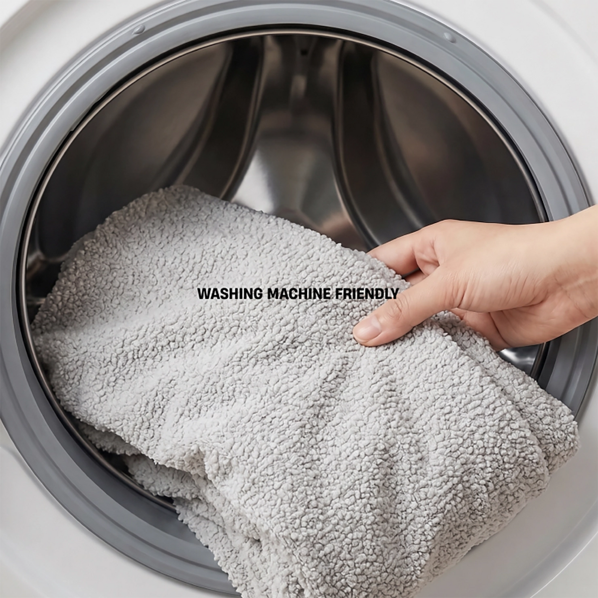 Grey bouclé replacement cover being placed in a washing machine with text reading “Washing Machine Friendly”.